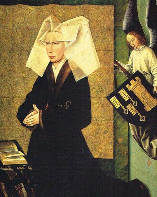 A woman in a black dress and a large white headdress stands with her hands clasped, looking contemplatively. An angel is seen beside her, holding a book with golden symbols.